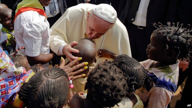 El papa Francisco besa a un niño durante su visita a un campo de refugiados en Bangui, República Centroafricana.