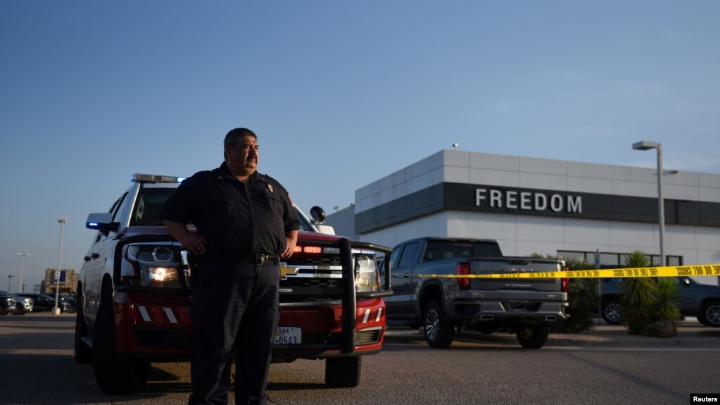 奥德萨消防救援队的一名成员在枪击事件后在一家汽车经销处监控现场，2019年9月1号， 路透社照片