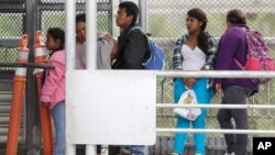 FILE- Immigrants seeking asylum in the United States wait on the the International Bridge in Reynosa, Mexico, Nov. 3, 2018. 