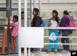 FILE - Immigrants seeking asylum in the United States wait on the the International Bridge in Reynosa, Mexico, Nov. 3, 2018.