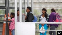 Inmigrantes que buscan asilo en Estados Unidos esperan en el Puente Internacional en Reynosa, Mexico, Nov. 3, 2018. 