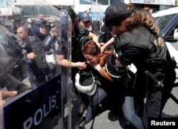 FILE - Turkish riot police scuffle with a group of protesters as they attempted to defy a ban and march on Taksim Square to celebrate May Day in Istanbul, Turkey, May 1, 2018.