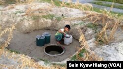 A village boy gathering water from dry sandy stream near Welaung Dam 