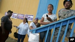 FILE - U.S. citizens wait in line to vote in the Democratic caucus at a high school in Charlotte Amalie, St. Thomas, U.S. Virgin Islands, Feb. 9, 2008.