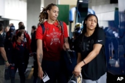 U.S. women's basketball players Brittney Griner, left, and Maya Moore board a bus at the airport after arriving at the 2016 Summer Olympics in Rio de Janeiro, Brazil, Aug. 3, 2016.