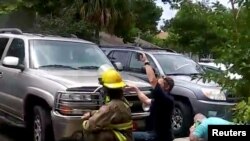 En esta imagen obtenida de un video en las redes sociales, se puede ver a personas ocultándose detrás de vehículos durante un tiroteo en Panama City, Florida. Facebook/Geraldine Rinaldi/ via Reuters. Mayo 22 de 2018.