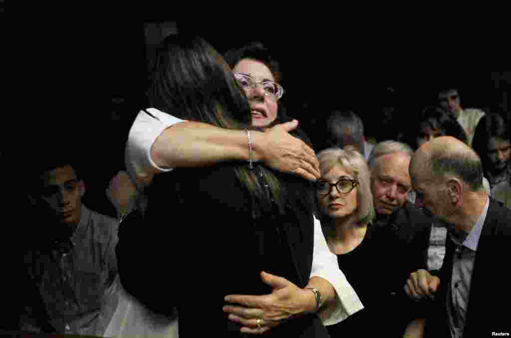 Relatives of Oscar Pistorius hug each other ahead of proceedings at the Pretoria magistrates court February 22, 2013. 
