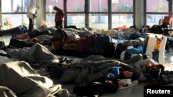 Refugees and migrants sleep inside a passenger terminal at the port of Piraeus, near Athens, Greece, Feb. 7, 2016. 