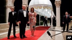 El presidente Trump habla con los reporteros a su llega a la gala en Mar-a-Lago para el Año Nuevo. Le acompañan su hijo Barron y la primera dama, Melania Trump.