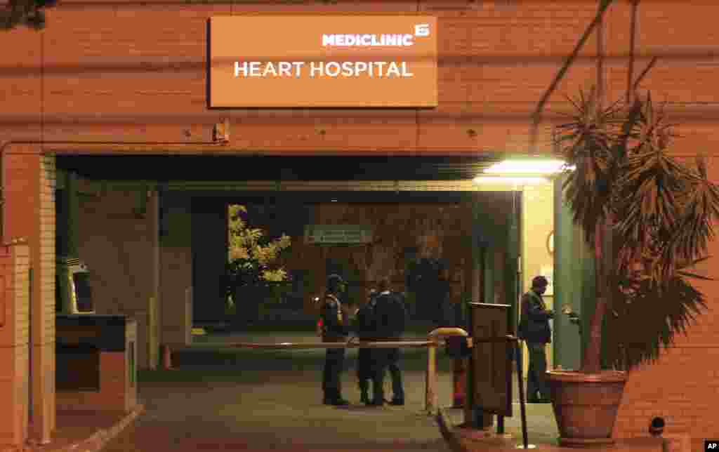 Police officers stand outside the main entrance of the Mediclinic Heart Hospital where former South African President Nelson Mandela is being treated in Pretoria, South Africa Sunday, Jun. 23, 2013. 