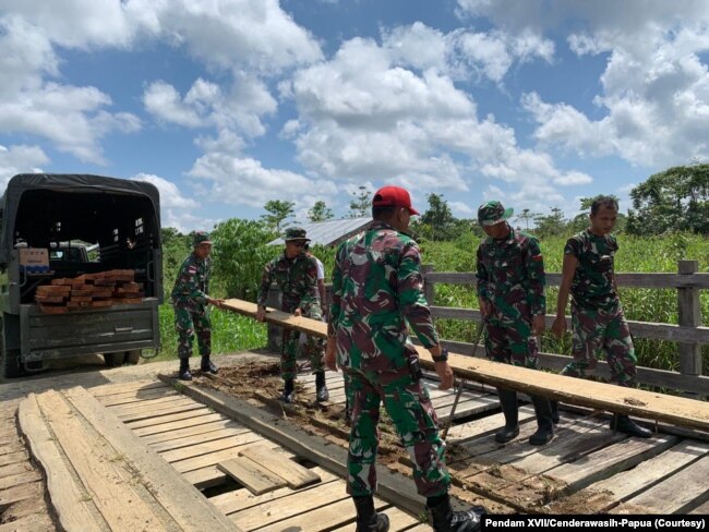 Satgas Pamtas Yonif Mekanis 403/Wirasada Pratista Pos Kotis bersama masyarakat perbatasan memperbaiki jembatan kayu yang rusak di Kampung Woslay, Distrik Senggi, Kabupaten Keerom, Papua, 17 Oktober 2021. (Courtesy: Pendam XVII/Cenderawasih-Papua)
