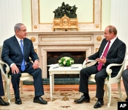 Russian President Vladimir Putin, right, speaks with Israeli Prime Minister Benjamin Netanyahu during their meeting at the Kremlin in Moscow, July 11, 2018.