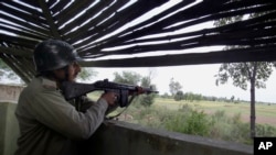 A Pakistani paramilitary soldier is seen inside a bunker monitoring an area on the border of Pakistan and India in Dhamala Hakimwala, Pakistan, Oct. 8, 2014.