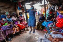 Jane Wakene (76, tengah), melakukan jumping jacks sebagai hukuman karena datang terlambat ke kelas bela diri taekwondo untuk perempuan di daerah kumuh Korogocho di Nairobi, Kenya, Kamis, 16 September 2021.