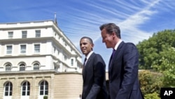 U.S. President Barack Obama and Britain's Prime Minister David Cameron walk in the gardens after holding a joint news conference at Lancaster House in London, May 25, 2011