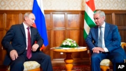 Russian President Vladimir Putin, left, and leader of Georgia's breakaway province of Abkhazia, Raul Khadzhimba, talk during their meeting in the provincial town of Pitsunda, Aug. 8, 2017. 