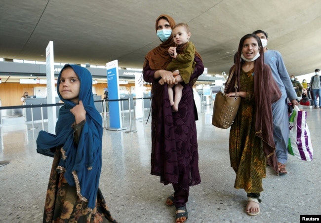 کابل سے ڈیلس ایئرپورٹ پہنچنے والا ایک افغان خاندان ایئرپورٹ سے باہر آ رہا ہے۔ 27 اگست 2021