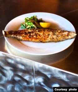 Roast Louisiana Gulf Fish by chefs Donald Link and Stephen Stryjewski in the Cochon Restaurant.  New Orleans cuisine uses seafood from the nearby Gulf of Mexico.  (Courtesy photo of Cochon Restaurant.)