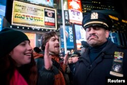 FILE - An NYPD officer, right, reacts to demonstrators protesting the July chokehold death of Eric Garner, in New York, Dec. 3, 2014. A grand jury returned no indictment against white officers in his death.