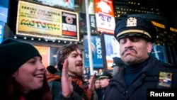 Một cảnh sát đứng cạnh nhóm người biểu tình phản đối ở New York
