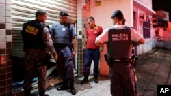 Military police check the broken entrance of a store that was looted in Vitoria, Espirito Santo state, Brazil, Feb 8, 2017.