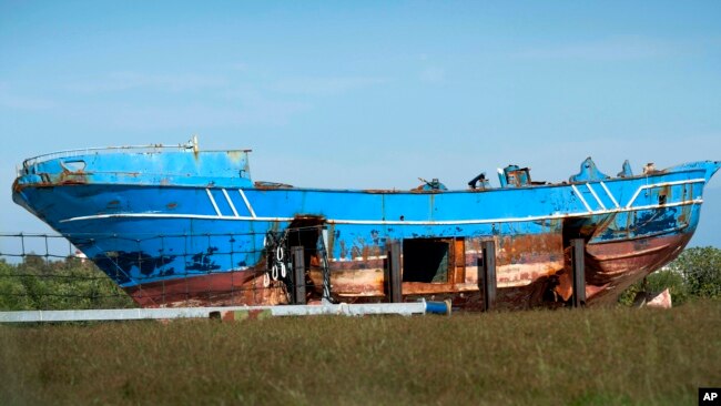 FILE - The wrecked fishing boat that capsized and sunk on April 18, 2015, off the coast of Libya, lies outside a NATO base in the Sicilian town of Mellili, Italy, Oct. 8, 2016.