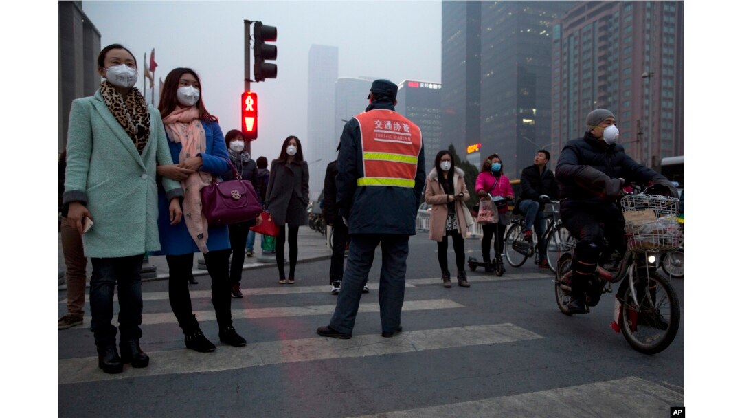 FILE - Pedestrians wear masks to protect against heavy pollution on the streets of Beijing. (VOA News)