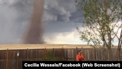 Theunis Wessels mows his lawn in Alberta, Canada, with a tornado in the distance.