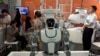 FILE - Visitors to the 21st China Beijing International High-tech Expo look at robots and helicopter drone displayed in Beijing, China, May 17, 2018. 