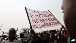 A protester holds a banner on the fourth day of a nationwide strike against the removal of the petrol subsidy in Lagos, January 12, 2012.
