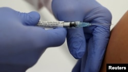 Le professeur Gottfried Kremsner injecte un vaccin contre le COVID-19 de la société de biotechnologie allemande CureVac à un volontaire de son institut tropical de la clinique universitaire de Tuebingen, en Allemagne, le 22 juin 2020. REUTERS / Kai Pfaffenbach