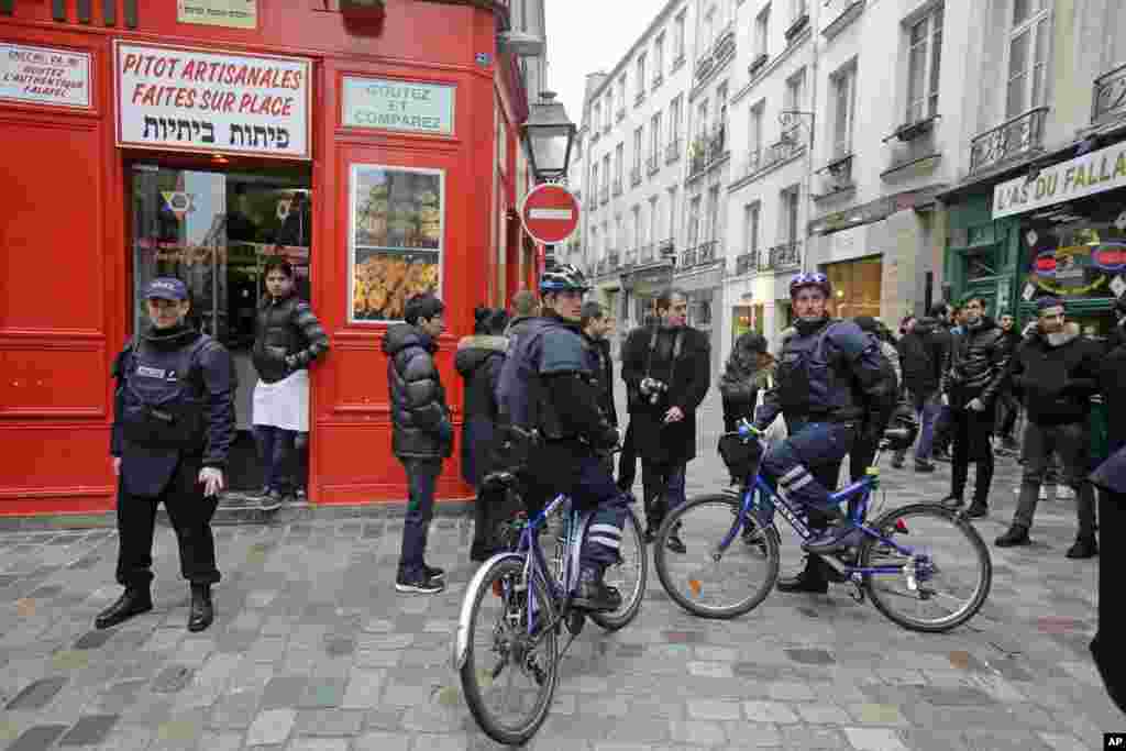 Police officers on bicycles patrol Rue des Rosiers in the heart of the Paris Jewish quarter, Jan. 12, 2015.