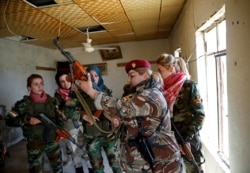 Pejuang perempuan Kurdi Irak Haseba Nauzad (kedua dari kanan), 24, memegang senjatanya, dikelilingi rekan-rekannya di dekat garis depan perang melawan militan ISIS di Nawaran dekat Mosul, Irak, 20 April 2016. (Foto:REUTERS/Ahmed Jadallah).