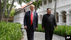 FILE - U.S. President Donald Trump and North Korea leader Kim Jong Un walk from their lunch at the Capella resort on Sentosa Island in Singapore, June 12, 2018. 