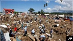 Policemen search for missing Typhoon Washi victims in a subdivision in Iligan city, southern Philippines. Disaster agencies on Monday rushed to deliver body bags, food, water, and medicine to crowded evacuation centers in the southern Philippines as offic