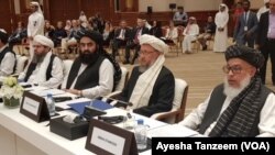 Anggota kantor politik Taliban tambak di ruang konferensi di Doha pada awal pembicaraan dua hari antara Taliban dan politisi Afghanistan, 7-8 Juli 2019.