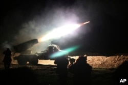 FILE - Soldiers from the Syrian army fire a rocket at Islamic State group positions in the province of Raqqa, Syria, Feb. 17, 2016.