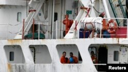 Crew members of the Panama-flagged cargo ship MV Asphalt Venture look out from the ship at the Kenyan Port of Mombasa, April 28, 2011. 