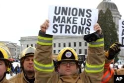 FILE - A firefigher holds a pro-union sign at a rally in Olympia, Wash., Feb. 26, 2011.