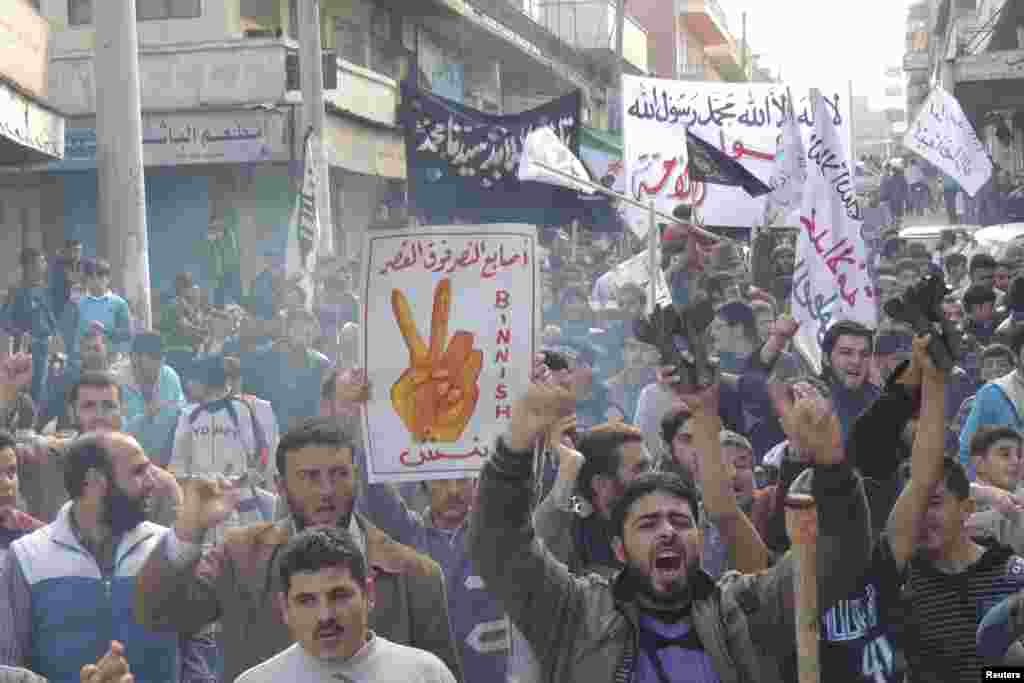 Demonstrators hold a placard that reads "Victory sign over the palace," during a protest against Syria's President Bashar al-Assad after Friday prayers in Binsh, November 30, 2012.