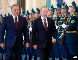 FILE - Russian President Vladimir Putin, second from left, and Kazakh President Nursultan Nazarbayev attend an official welcome ceremony in Astana, Kazakhstan, Oct. 15, 2015.