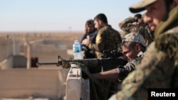 A Syrian Democratic Forces fighter looks through the scope of his weapon in Tal Samin village, north of Raqqa, Syria, Nov. 19, 2016.