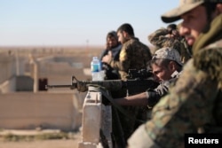 FILE - A Syrian Democratic Forces fighter looks through the scope of his weapon in Tal Samin village, north of Raqqa, Syria, Nov. 19, 2016.