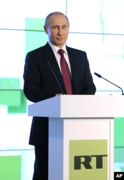 FILE - Russian President Vladimir Putin speaks as he attends an exhibition marking the 10th anniversary of RT's (formerly Russia Today) 24-hour English-language TV news channel in Moscow, Russia, Dec. 10, 2015.