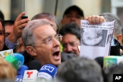 Former President and opposition Senator Alvaro Uribe shows a clip of a news article with a headline reading in Spanish "FARC puts a C4 collar around the neck of a Venezuelan," after voting in a referendum to decide whether or not to support a peace deal signed between the Colombian government and rebels of the Re