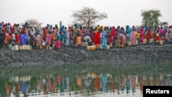 Displaced women gather to collect water from a water hole near Jamam refugee camp in South Sudan's Upper Nile State, March 10, 2012.