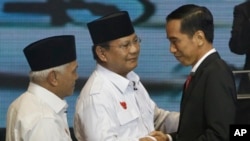 Calon-calon presiden Joko Widodo dan Prabowo Subianto, bersama calon wakil presiden Prabowo, Hatta Rajasa usai debat di Jakarta (9/6). (AP/Dita Alangkara)