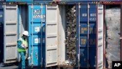 FILE - A Malaysian official inspects a container filled with plastic waste shipment prior to sending it to the Westport in Port Klang, Malaysia, May 28, 2019.