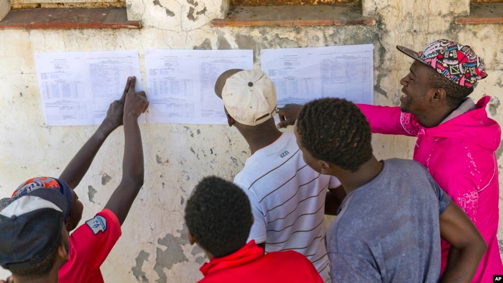 Les Zimbabwéens vérifient les résultats affichés à l'extérieur d'un bureau de vote à Bulawayo, au Zimbabwe, le 31 juillet 2018. 