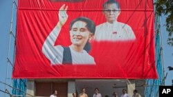 Lidè Lig Nasyonal pou Demokrasi a, Aung San Suu Kyi (bra anlè), pandanli tap fè yon diskou sou balkon katye jeneral pati a nan Ranngoun, Bimani, nan jounen lendi 9 novanm 2015 la.